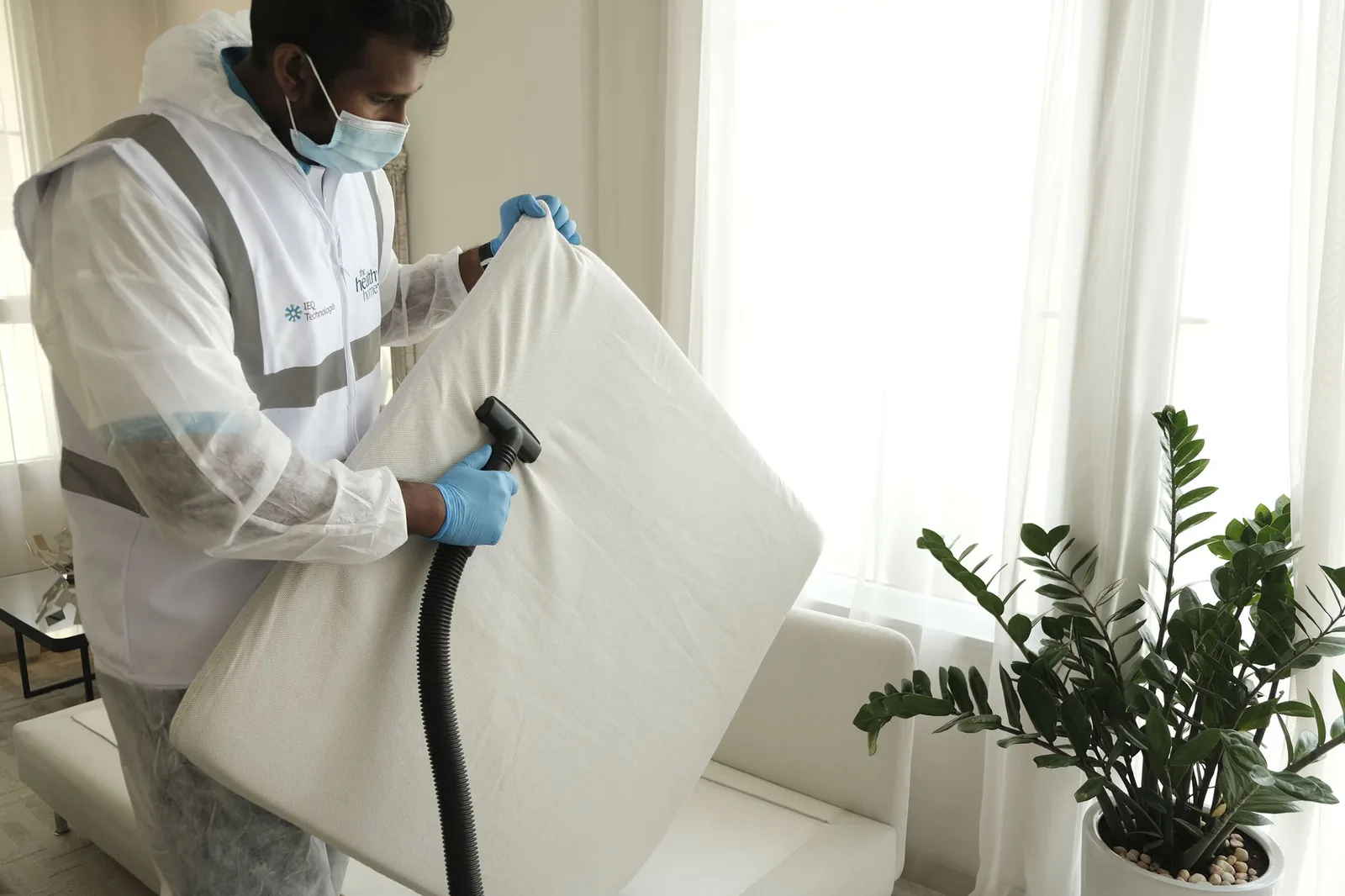 Nhân viên vệ sinh hút bụi nệm bằng máy chuyên dụng